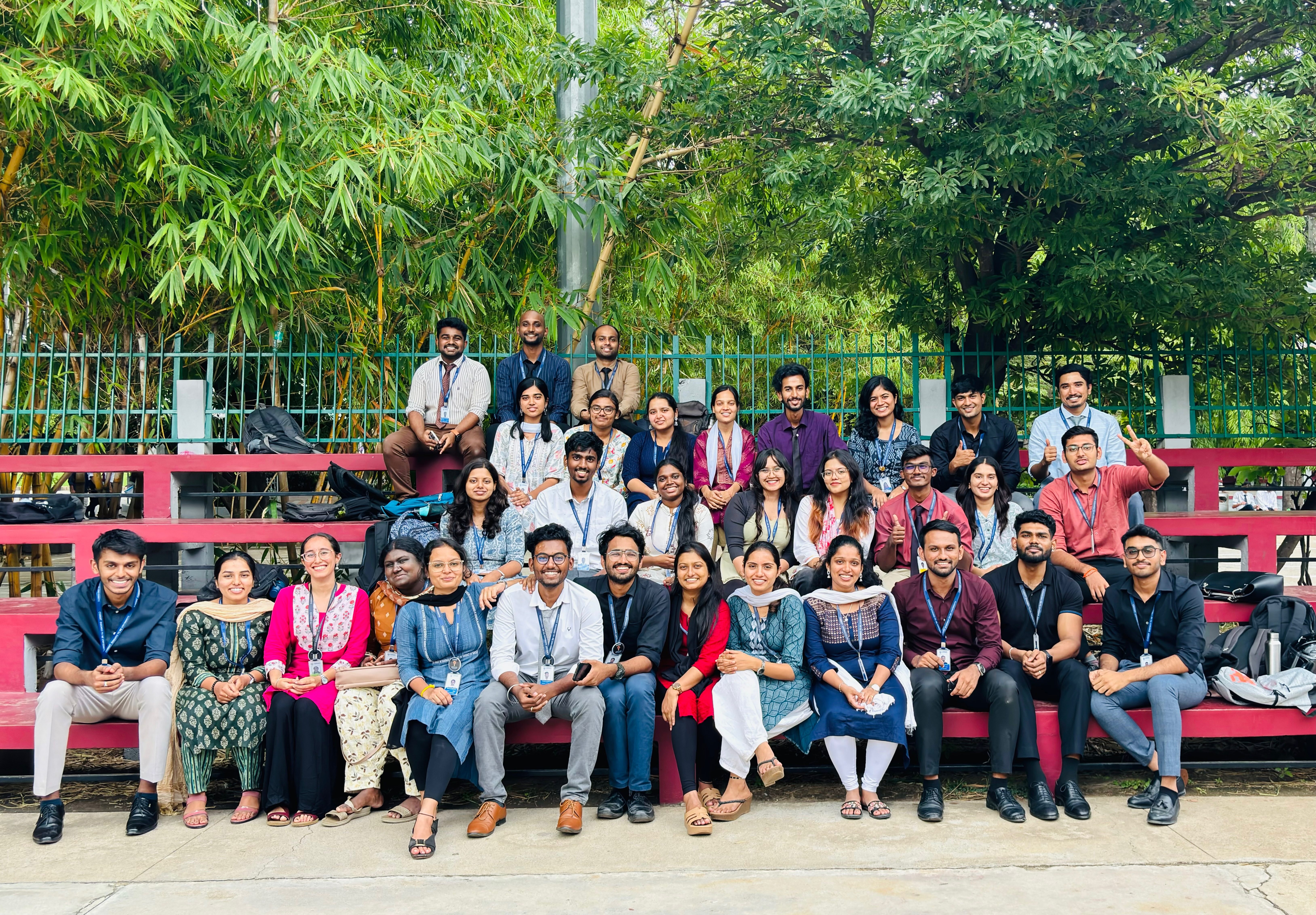 Roshan Rajkumar Sivakumar and MBA Pioneer Club members at first icebreaker meet Christ University Bengaluru 2024 — group photo on outdoor bleachers with bamboo trees