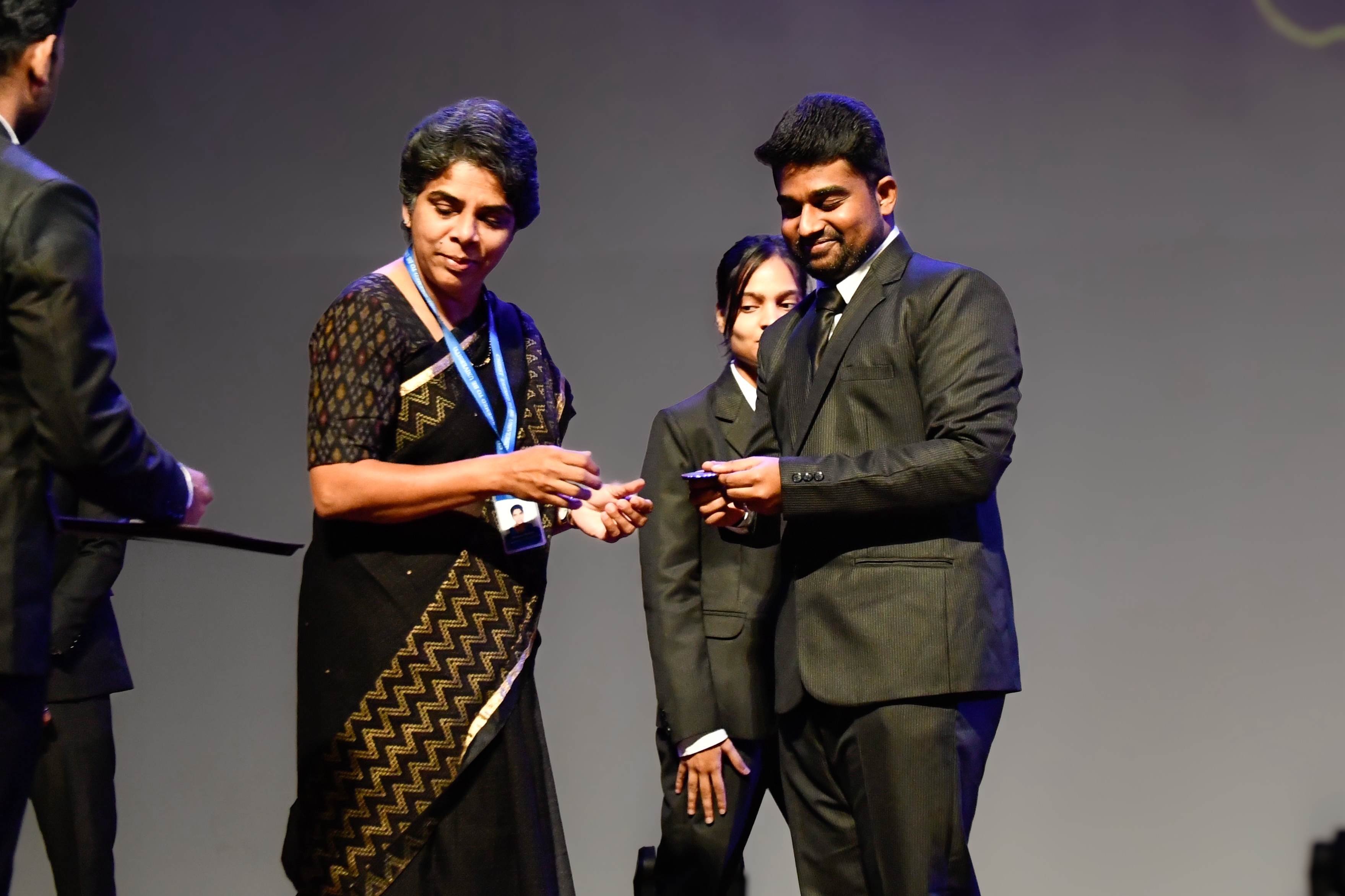 Roshan Rajkumar Sivakumar receiving Pioneer Club membership badge on stage at Christ University Bengaluru Curtain Riser inaugural event 2024