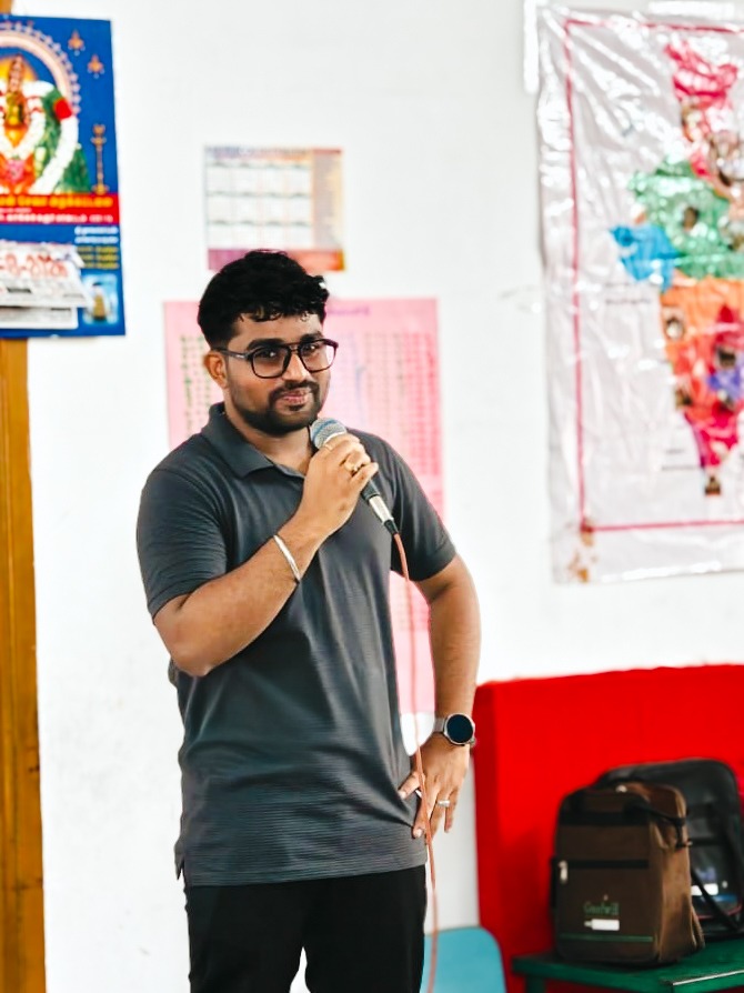 Roshan R Sivakumar delivering live corporate training with microphone